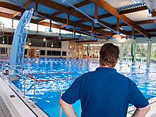 Schwimmmeister von hinten vor dem Sportbecken